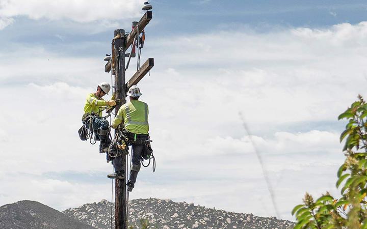 line workers on electric pole
